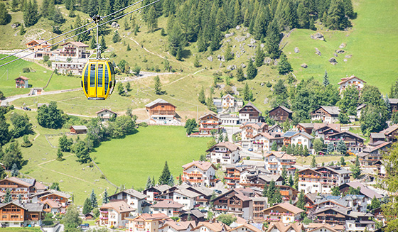 A cabin of the Boè cable car passes over the village of Corvara