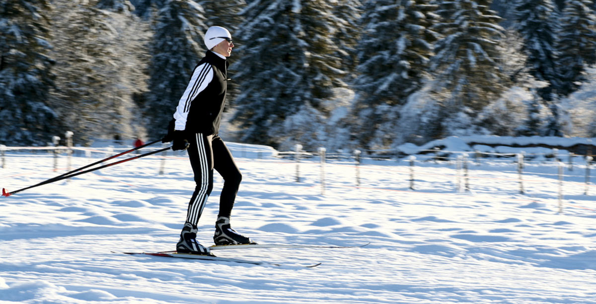 Eine Person in Schwarz-Weißer Bekleidung beim Langlaufski-Fahren